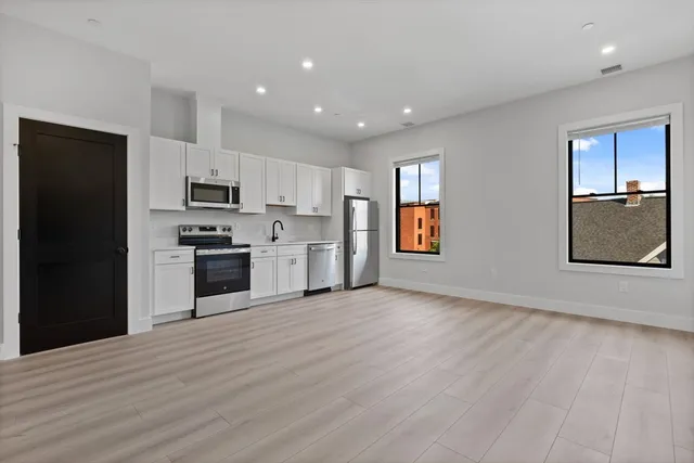 a view of kitchen with sink and refrigerator