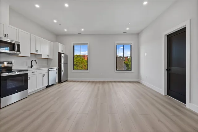 a view of a kitchen with wooden floor and electronic appliances