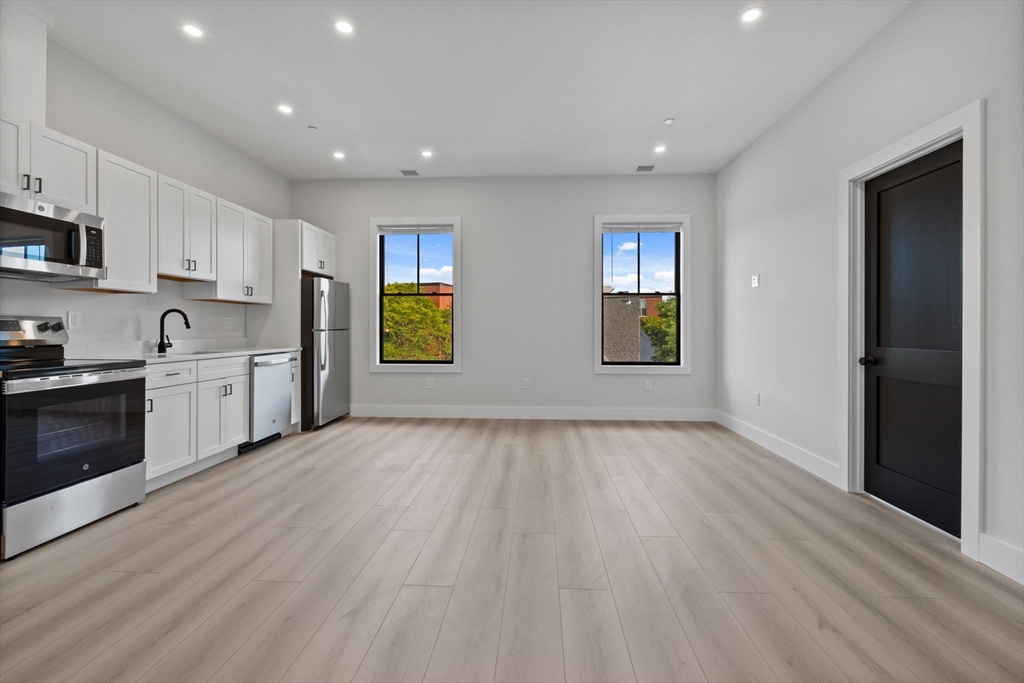 198 Albion Street, Unit 202 Wakefield, MA 01880 - Photo 2 of 13 a view of a kitchen with wooden floor and electronic appliances