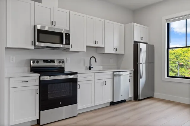 a kitchen with stainless steel appliances granite countertop a stove a refrigerator and a microwave