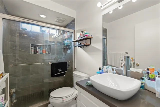 a bathroom with a sink a toilet and shower