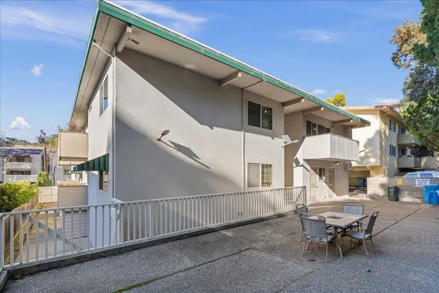 a view of a patio with table and chairs with wooden floor and fence