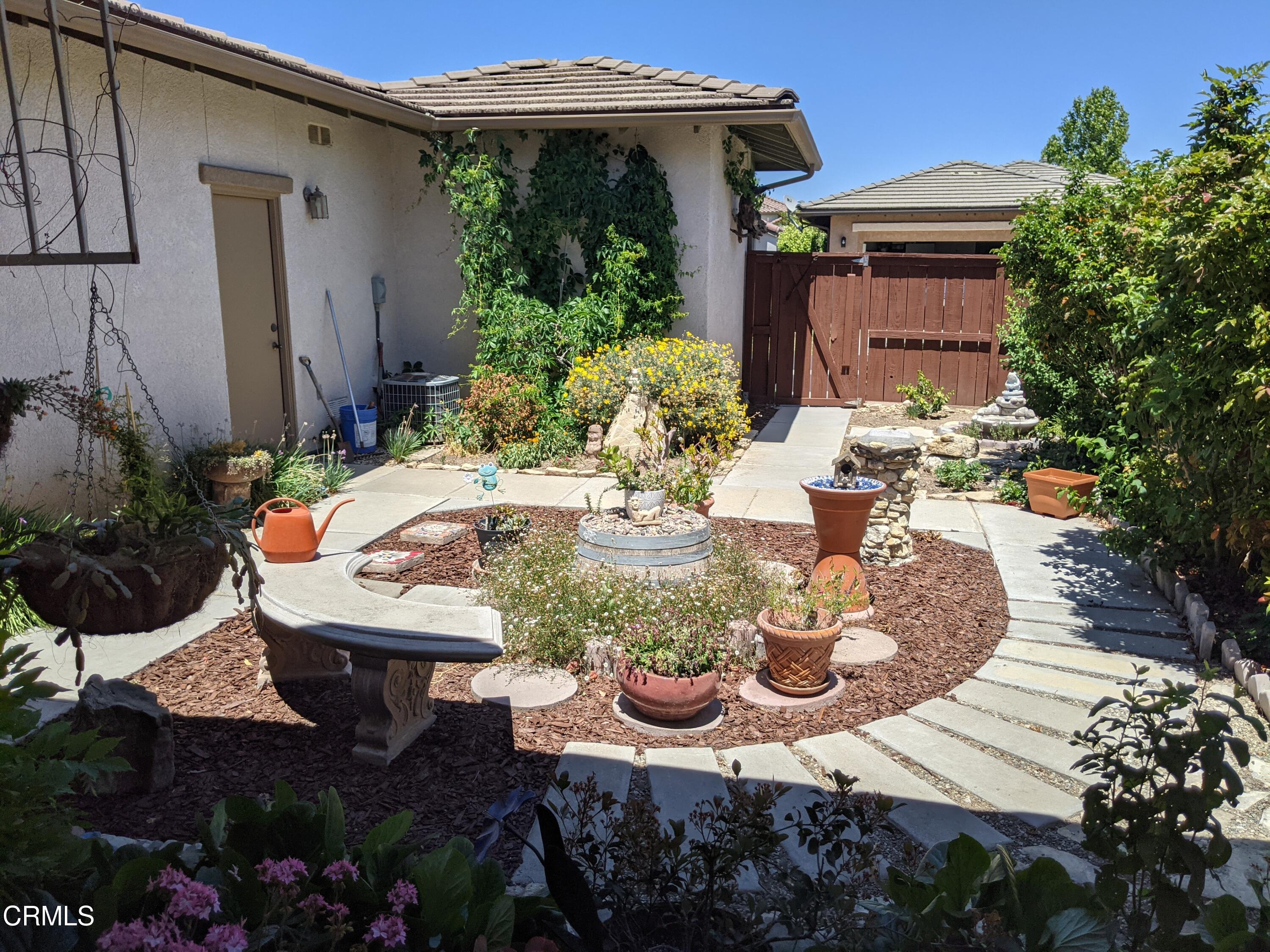 2654 Traditions Loop Paso Robles, CA 93446 - Photo 12 of 32 a view of a patio with table and chairs potted plants