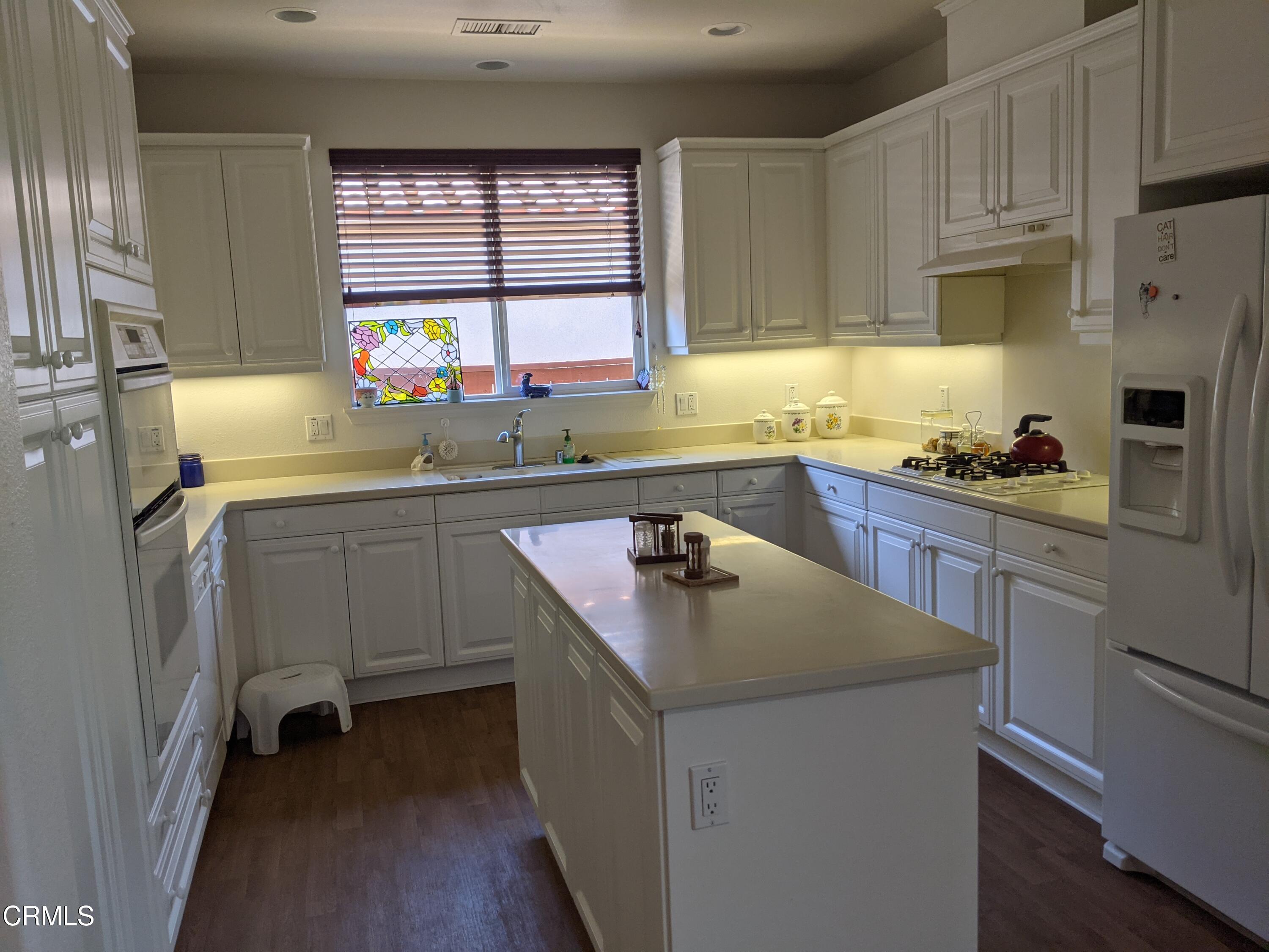 2654 Traditions Loop Paso Robles, CA 93446 - Photo 14 of 32 a kitchen with a sink a stove a refrigerator and cabinets