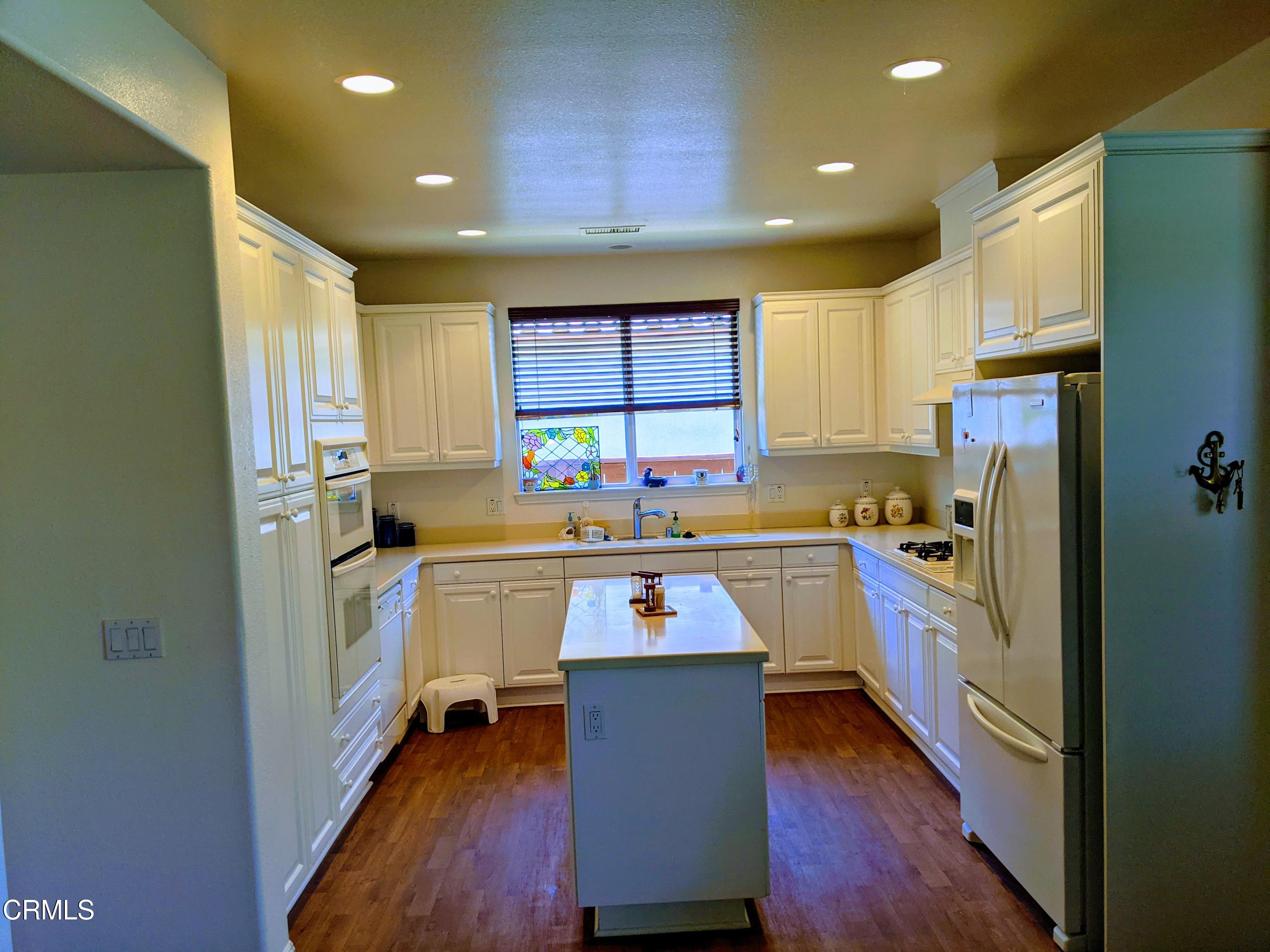 2654 Traditions Loop Paso Robles, CA 93446 - Photo 15 of 32 a kitchen with stainless steel appliances granite countertop a refrigerator a sink dishwasher a stove and white countertops with wooden floor