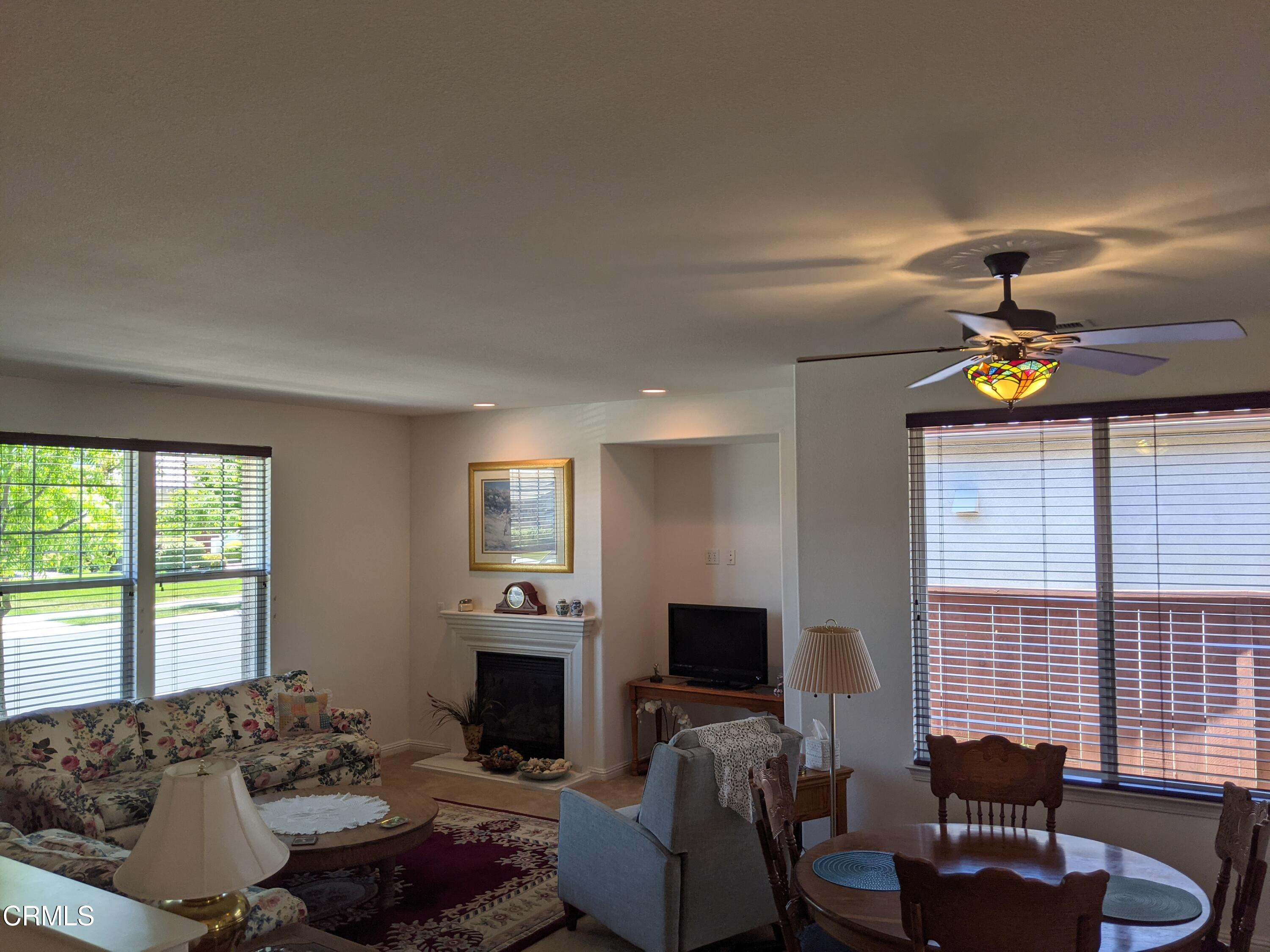2654 Traditions Loop Paso Robles, CA 93446 - Photo 3 of 32 a living room with furniture a fireplace and a flat screen tv