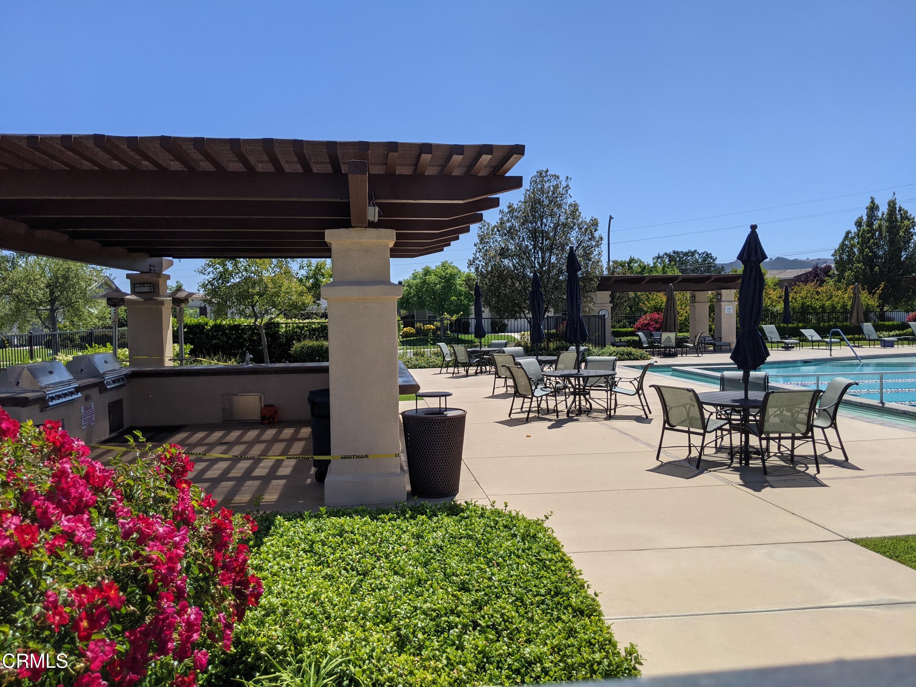 2654 Traditions Loop Paso Robles, CA 93446 - Photo 32 of 32 a view of a patio with table and chairs potted plants and palm trees