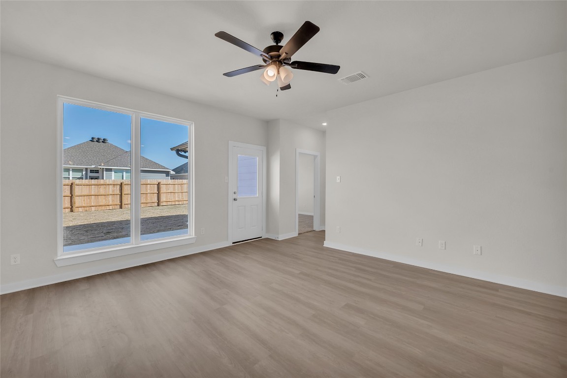 121 Walk Way Jarrell, TX 76537 - Photo 16 of 29 Empty room with visible vents, baseboards, a ceiling fan, and wood finished floors