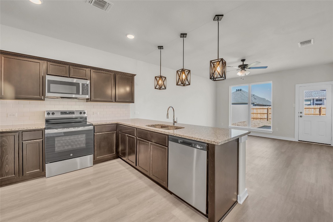 121 Walk Way Jarrell, TX 76537 - Photo 19 of 29 Kitchen with a sink, visible vents, dark brown cabinetry, and appliances with stainless steel finishes