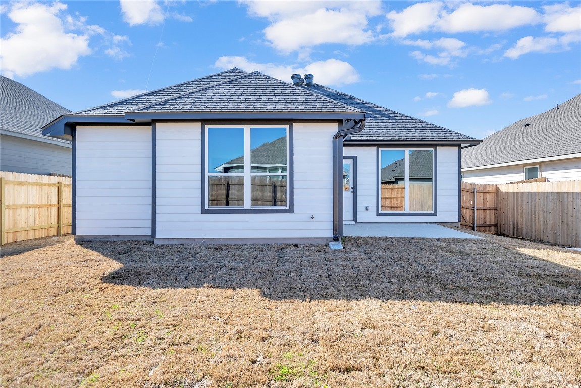 121 Walk Way Jarrell, TX 76537 - Photo 29 of 29 Back of property featuring a patio area, a yard, a fenced backyard, and roof with shingles