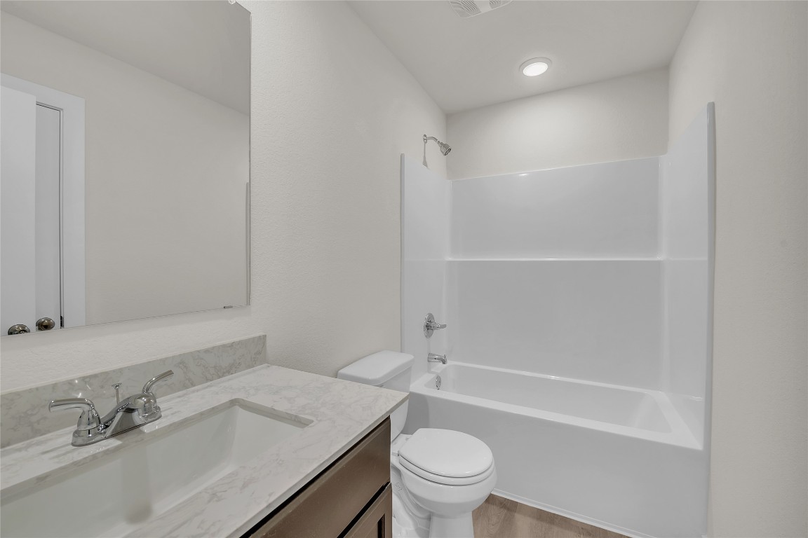 121 Walk Way Jarrell, TX 76537 - Photo 3 of 29 Full bath with bathing tub / shower combination, toilet, wood finished floors, and vanity