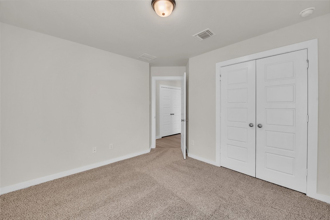 121 Walk Way Jarrell, TX 76537 - Photo 5 of 29 Unfurnished bedroom with carpet flooring, baseboards, visible vents, and a closet