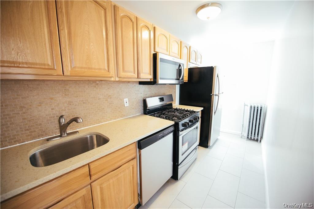1443 Beach Avenue Bronx, NY 10460 - Photo 12 of 25 a kitchen with stainless steel appliances granite countertop a sink stove and refrigerator
