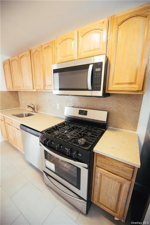 1443 Beach Avenue Bronx, NY 10460 - Photo 14 of 25 a kitchen with stainless steel appliances granite countertop a stove and a microwave