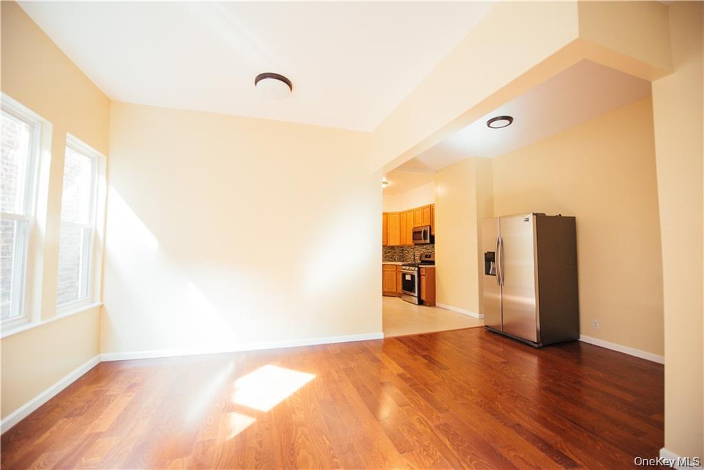 1443 Beach Avenue Bronx, NY 10460 - Photo 2 of 25 a view of an empty room with wooden floor and a window