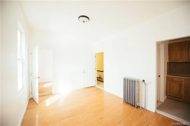 a view of a hallway to a room with wooden floor