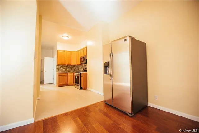 a view of a refrigerator in kitchen and wooden floor