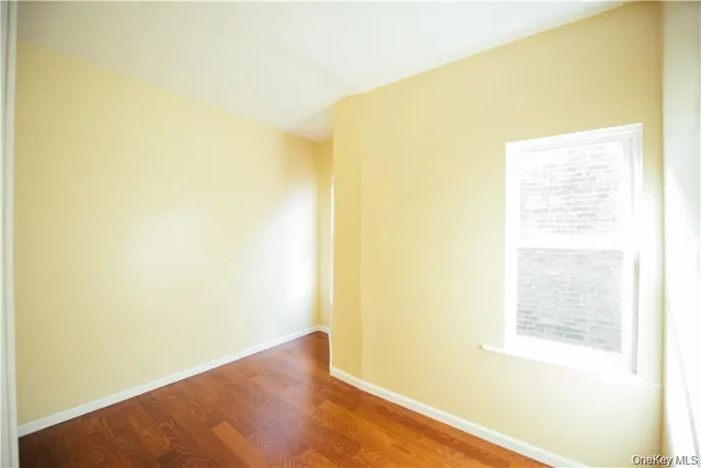 a view of a big room with wooden floor and a window