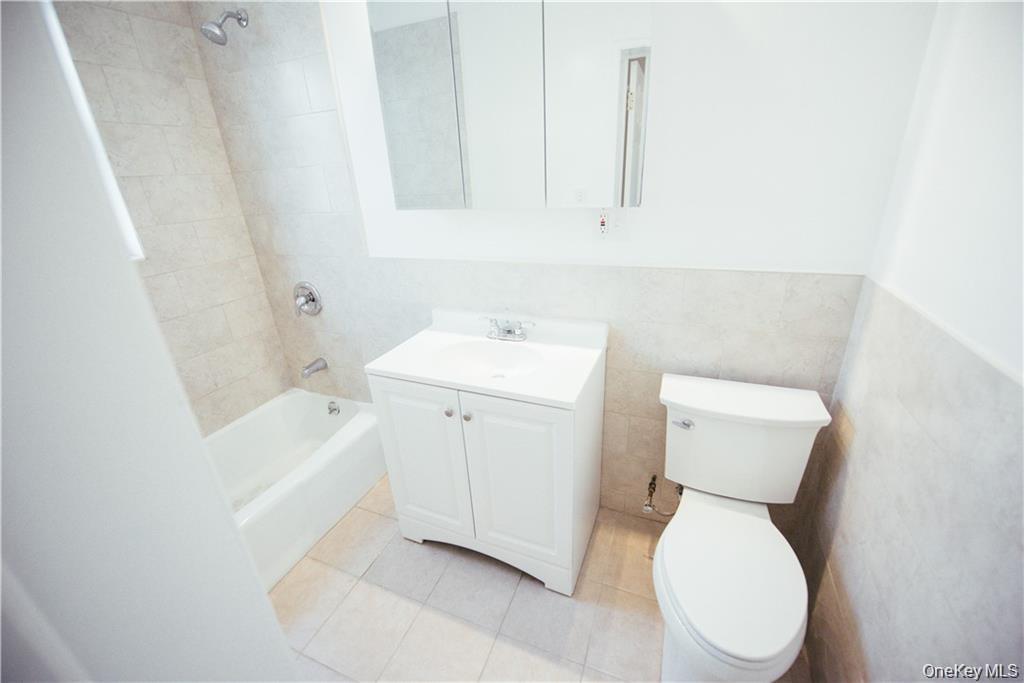 1443 Beach Avenue Bronx, NY 10460 - Photo 9 of 25 a white toilet sitting next to a bathroom sink