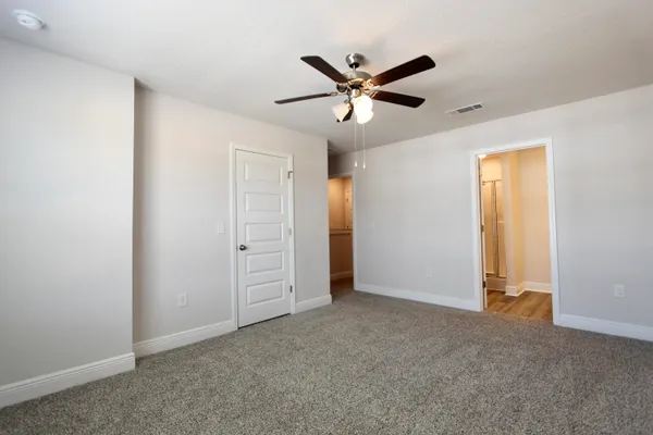 a view of a livingroom with a ceiling fan & entryway