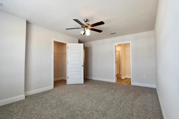 a view of an empty room with a ceiling fan