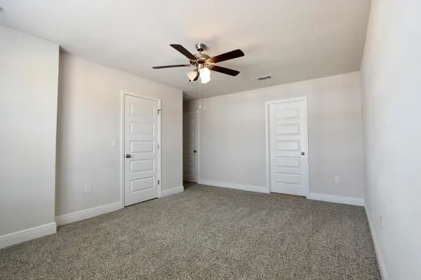 an empty room with closet and windows