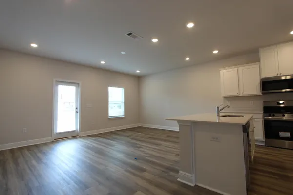 an empty room with wooden floor and entrance