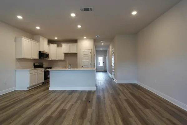 a view of kitchen with cabinets stainless steel appliances and wooden floor