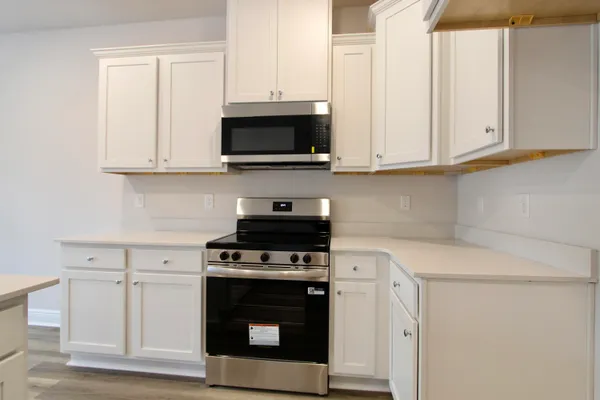 a kitchen with white cabinets and black appliances