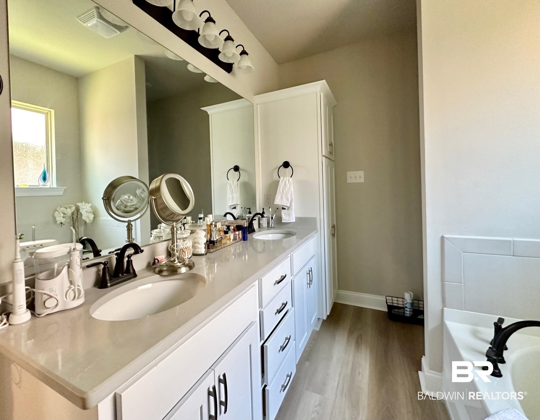 1009 Ruisseau Drive Foley, AL 36535 - Photo 40 of 55 Bathroom with vanity, wood-type flooring, and a bathtub