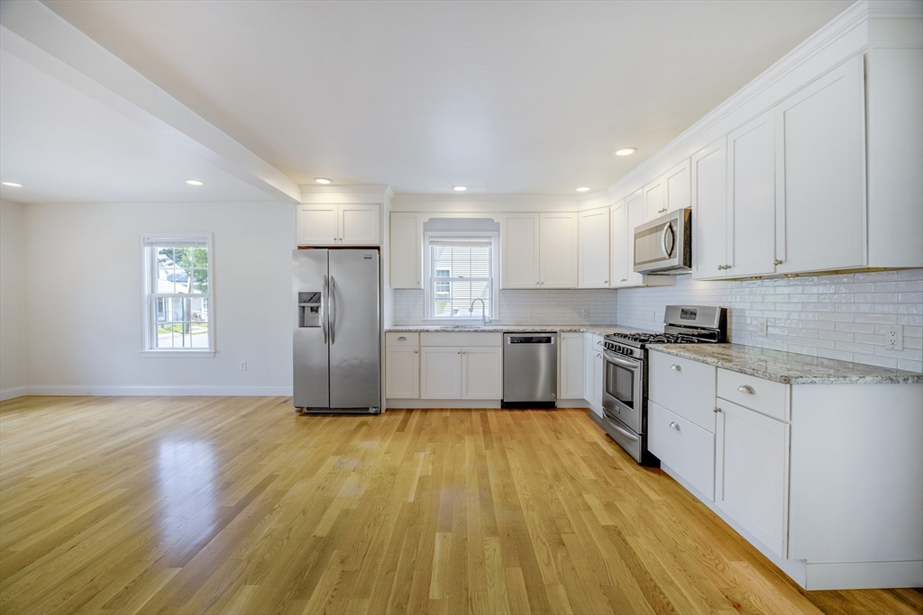 48 Spruce Street, Unit 1 Winchester, MA 01890 - Photo 2 of 29 a kitchen with wooden floors appliances and cabinets