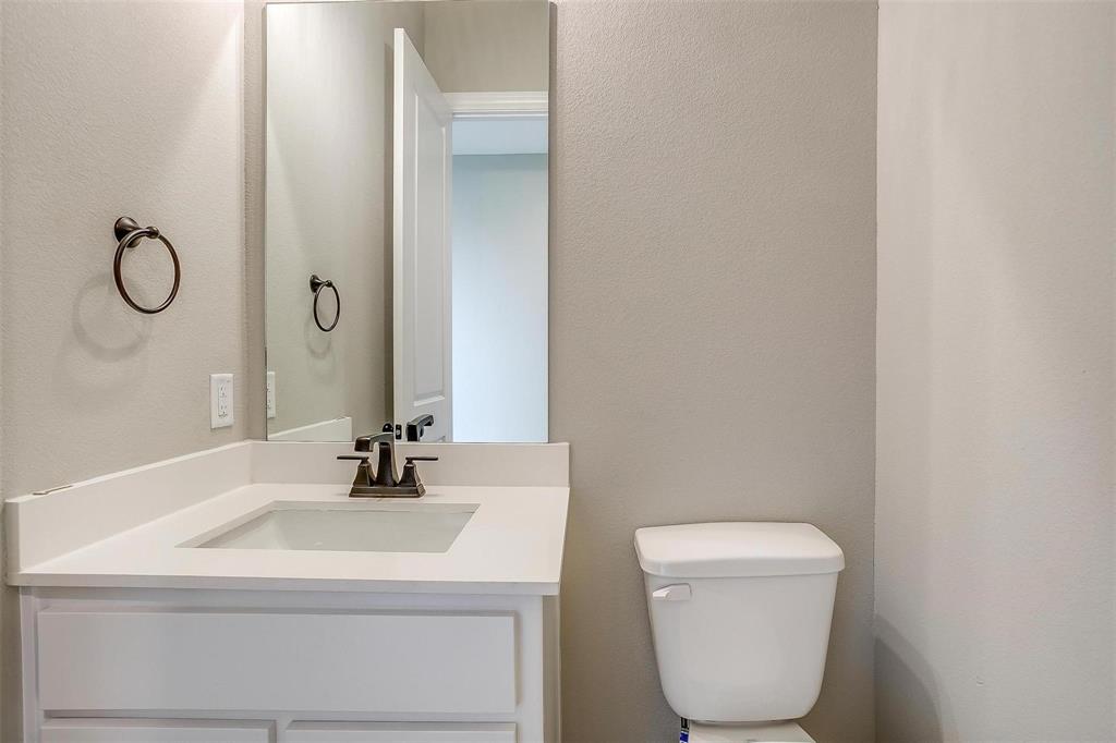 2316 Builder Road Crowley, TX 76036 - Photo 18 of 34 a bathroom with a toilet a sink and mirror
