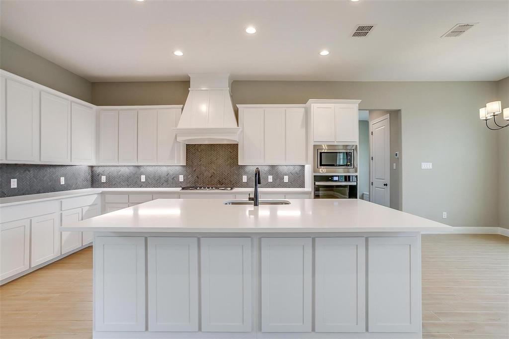 2316 Builder Road Crowley, TX 76036 - Photo 10 of 34 a kitchen with kitchen island granite countertop a sink counter space cabinets and stainless steel appliances