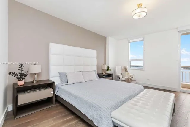 a bedroom with a large bed and a potted plant