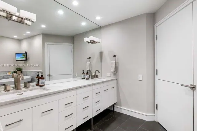 a bathroom with a double vanity sink mirror and shower