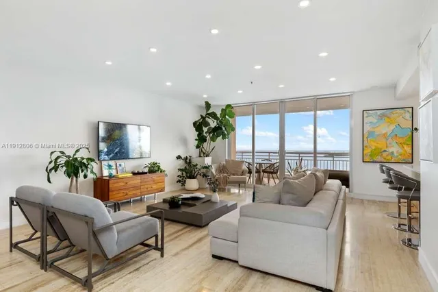 a view of a hallway with wooden floor and a living room