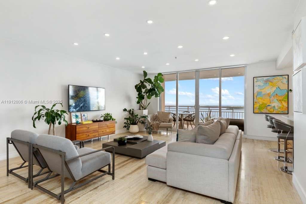 808 Brickell Key Drive, Unit 2504 Miami, FL 33131 - Photo 19 of 26 a living room with furniture and a flat screen tv