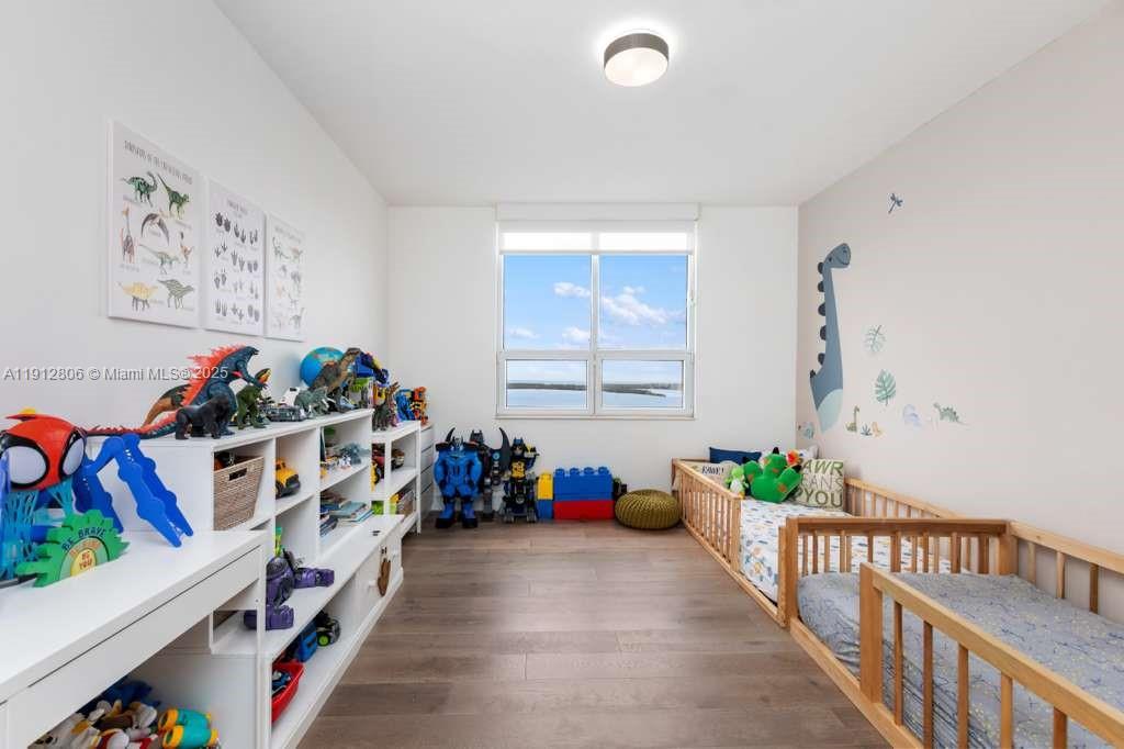 808 Brickell Key Drive, Unit 2504 Miami, FL 33131 - Photo 24 of 26 a bedroom with baby crib and a book shelf