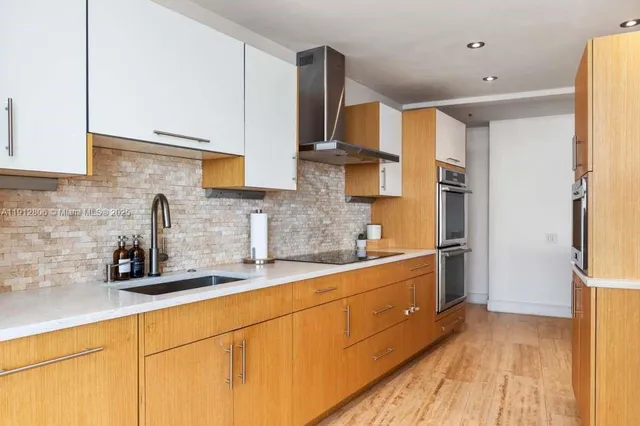 a kitchen with stainless steel appliances kitchen island granite countertop a table and chairs in it