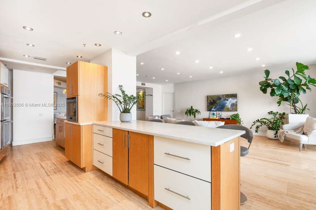808 Brickell Key Drive, Unit 2504 Miami, FL 33131 - Photo 5 of 26 a kitchen with stainless steel appliances kitchen island granite countertop a table and chairs in it