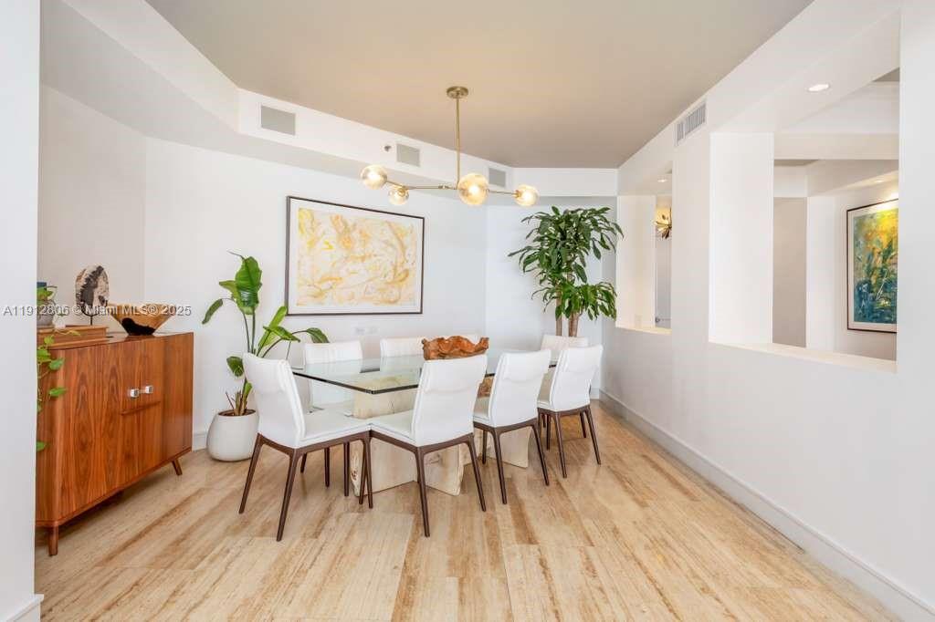 808 Brickell Key Drive, Unit 2504 Miami, FL 33131 - Photo 8 of 26 a dining room with furniture and wooden floor