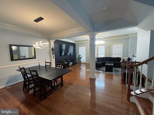 a view of a dining room and livingroom with furniture wooden floor a chandelier