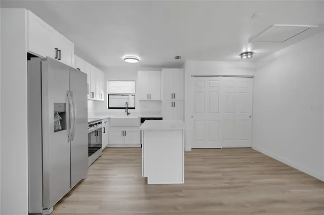 a kitchen with a refrigerator a stove top oven a sink dishwasher and wooden floor