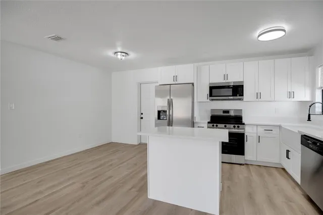 an empty room with a window and a ceiling fan