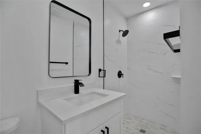 an empty room with wooden floor and ceiling fan