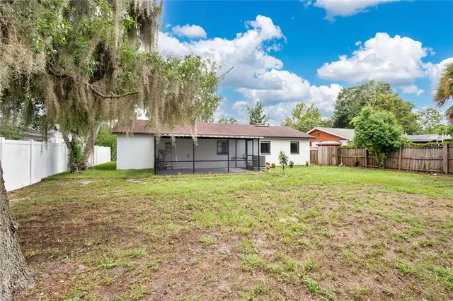 an aerial view of residential houses with outdoor space and trees