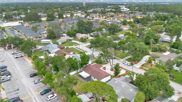 an aerial view of residential houses with outdoor space and trees