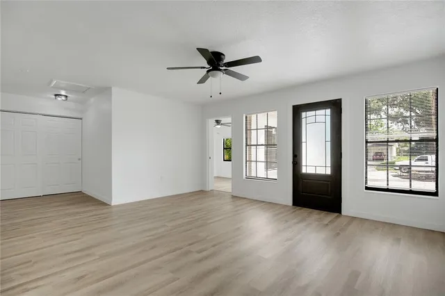 a view of a livingroom with a ceiling fan and wooden floor