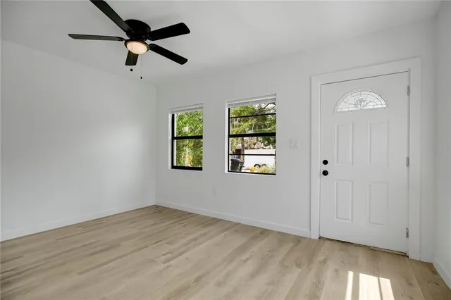 a view of empty room with wooden floor and window