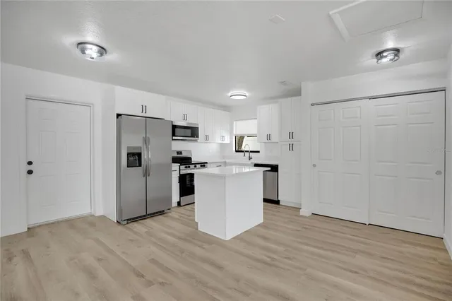 a kitchen with white cabinets and stainless steel appliances